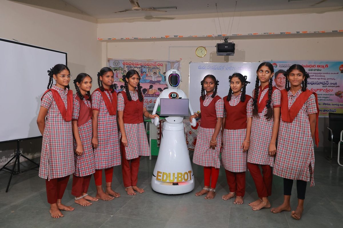 Students lined up beside EDU-BOT after a session